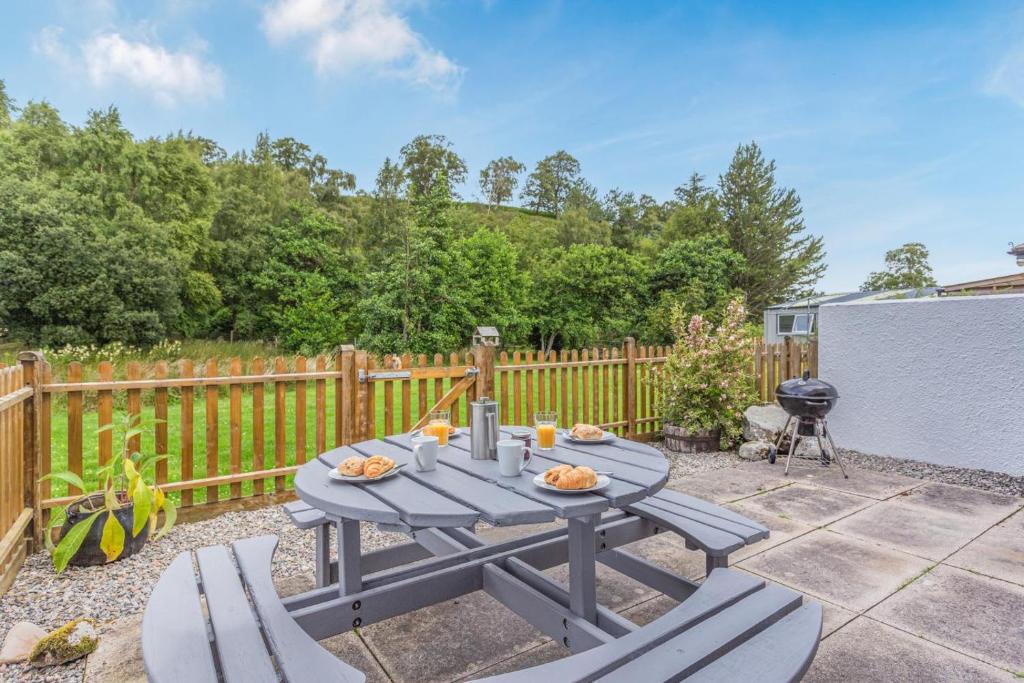 a blue picnic table and chairs on a patio at 2 Bed in Newtonmore oc-e32418 in Newtonmore