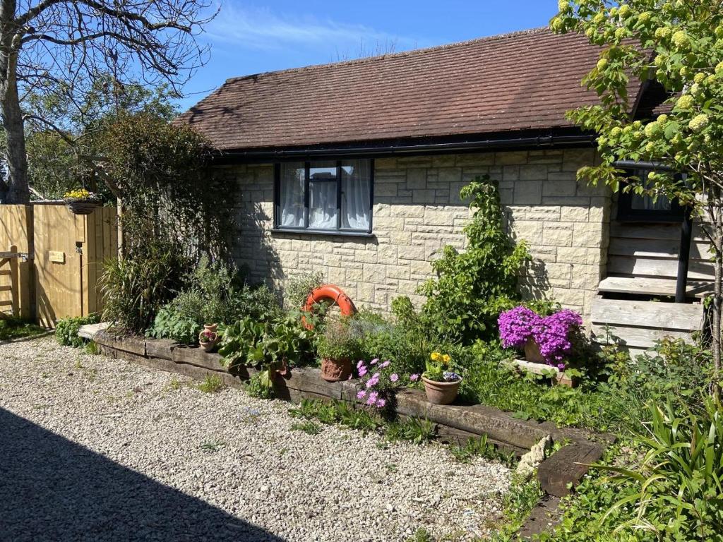 a small house with flowers in a garden at 1 Bed in Swanage oc-l30493 in Langton Matravers