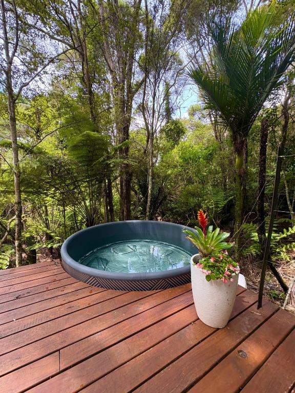 a hot tub sitting on top of a wooden deck at Tui Bush Chalet and Hot tub in Parakakau