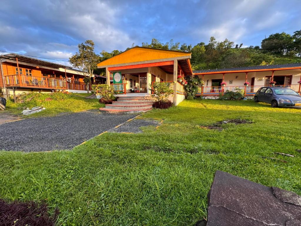 a house with a car parked in front of it at Kumanday Lodge in Pereira