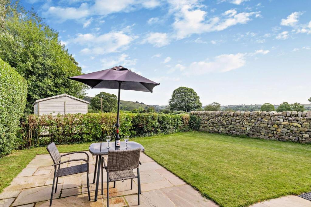 a table and chairs with an umbrella in a garden at 1 Bed in Warslow oc-h27591 in Warslow