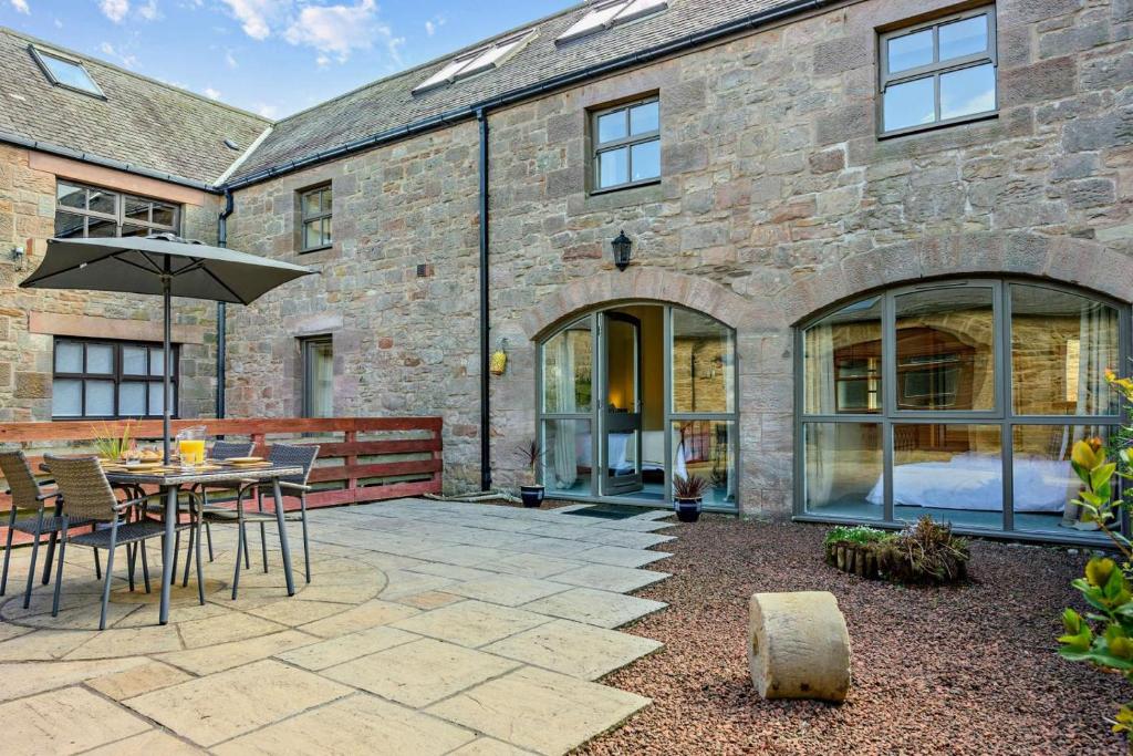 a patio with a table and chairs and an umbrella at 2 Bed in Belford oc-c29288 in Fenham