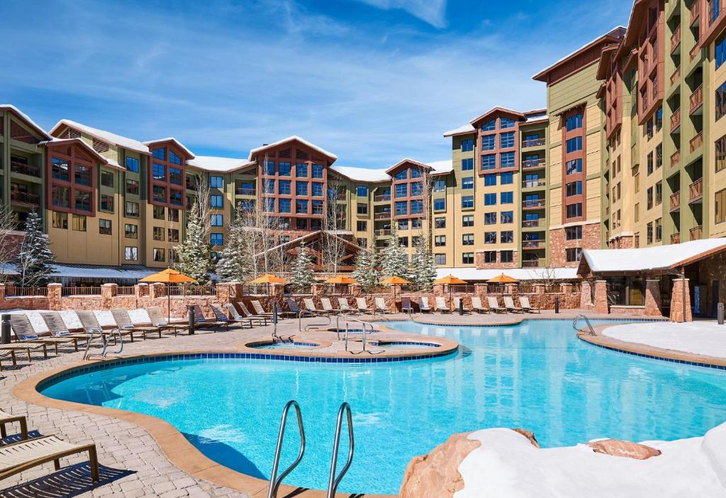ein Resort-Swimmingpool mit Stühlen und ein Hotel in der Unterkunft Grand Summit Hotel - Canyons Village, a RockResort in Park City