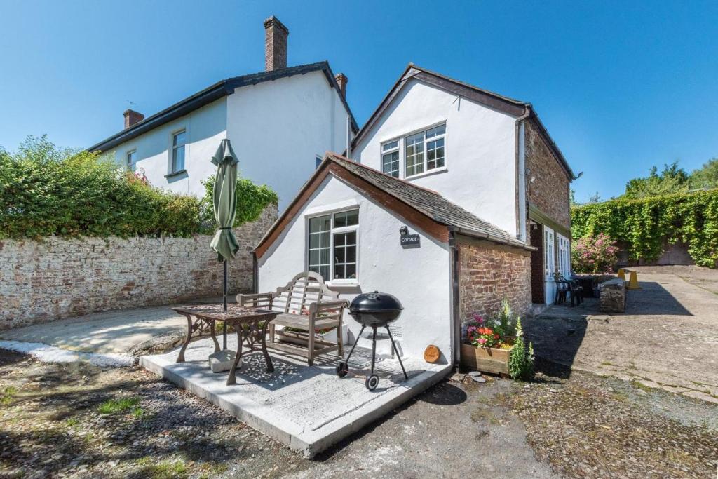 a table and a grill in front of a house at 2 Bed in Westward Ho oc-n0987 in Westward Ho