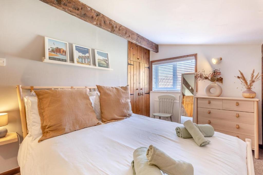 a bedroom with a white bed with a wooden headboard at 2 Bed in Sheringham oc-2310 in Sheringham