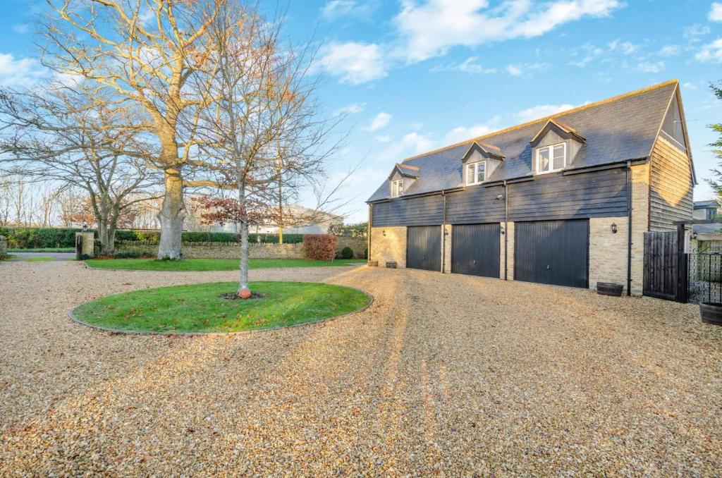 a barn style house with a tree in the driveway at 1 Bed in Woodstock oc-u30547 in Kidlington