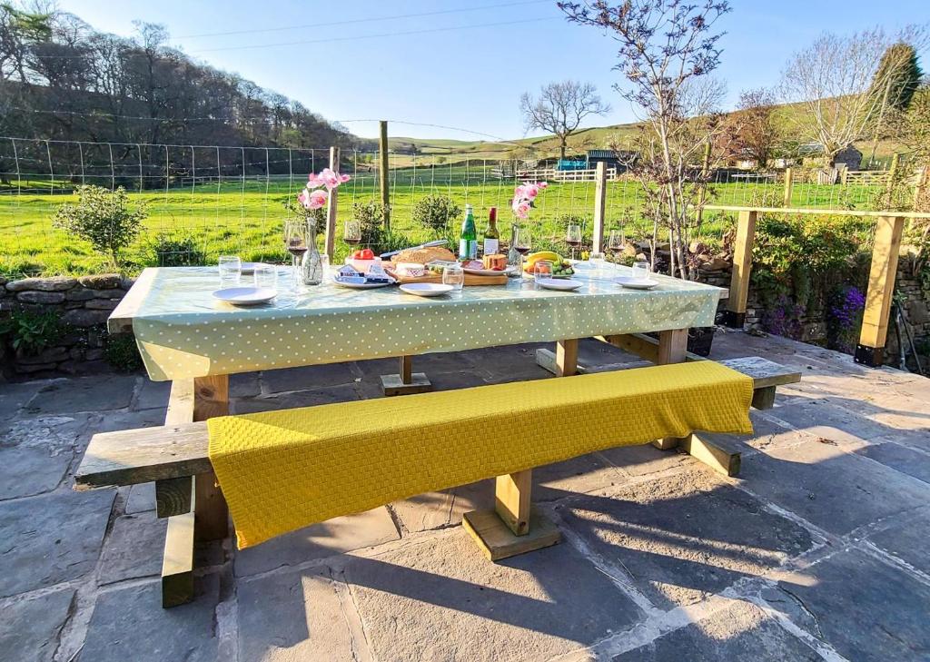 a picnic table with yellow cushions on a patio at 4 Bed in Little Hayfield oc-c31097 in Hayfield