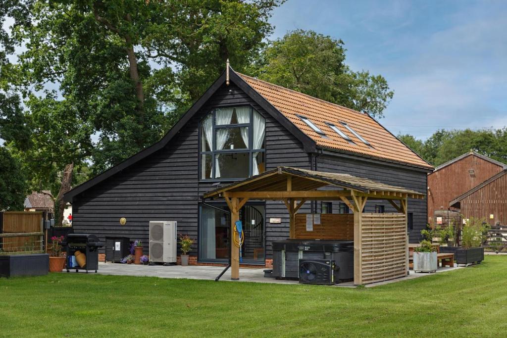 a black house with a gambrel roof with a stove at 4 Bed in Saham Toney oc-o30348 in Saham Toney