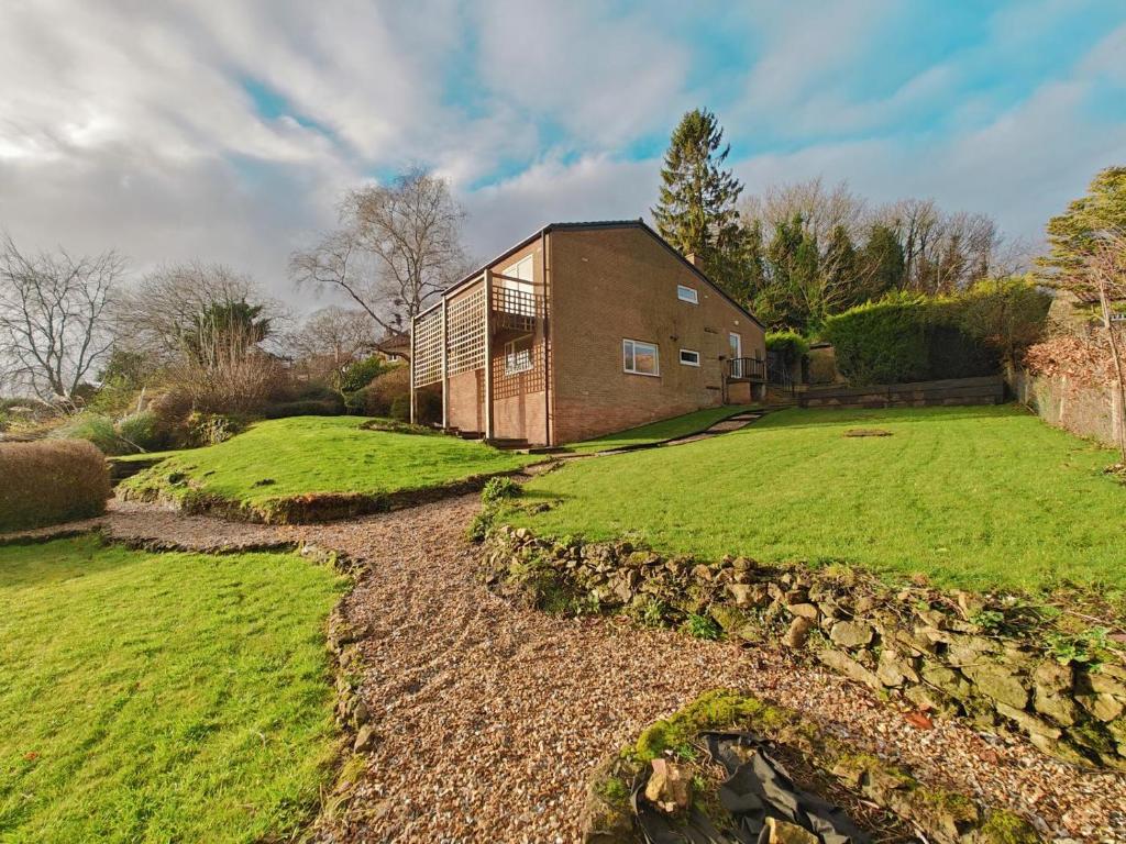 a brick house with a grassy yard next to a field at 5 Bed in Tealby oc-t30618 in Tealby