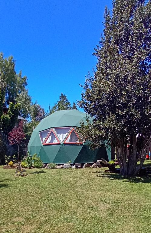 a green dome tent sitting on top of a field at Experiencia DOMO in San Carlos de Bariloche