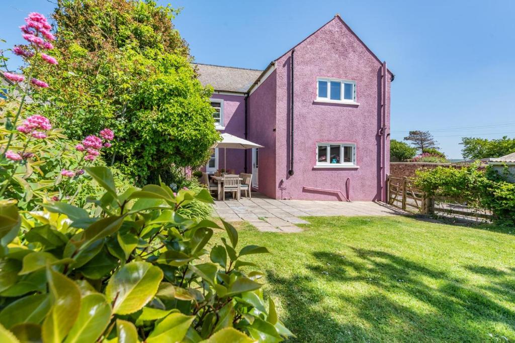 a pink house with a garden in front of it at 4 Bed in St. Brides oc-o30488 in Saint Brides