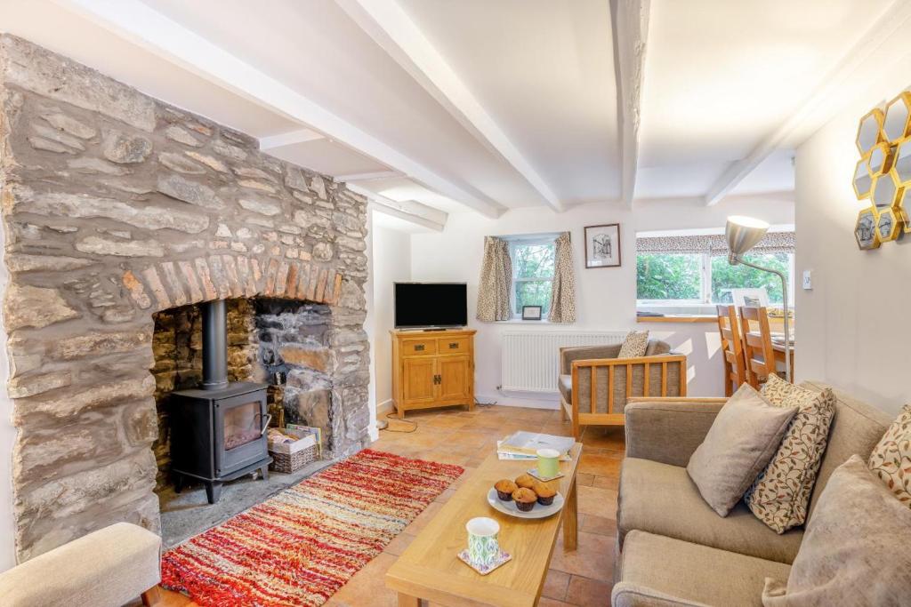 a living room with a stone fireplace and a couch at 2 Bed in Kirkcudbright oc-a30803 in Kirkcudbright