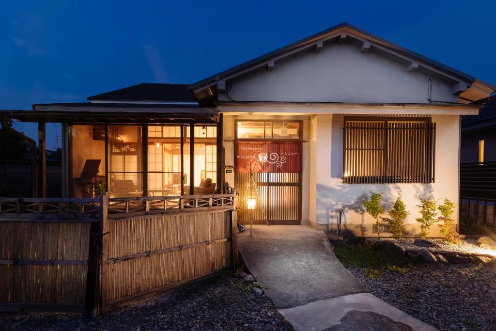 dom z drzwiami wejściowymi i ogrodzeniem w obiekcie Guest House Enishi w mieście Toyama