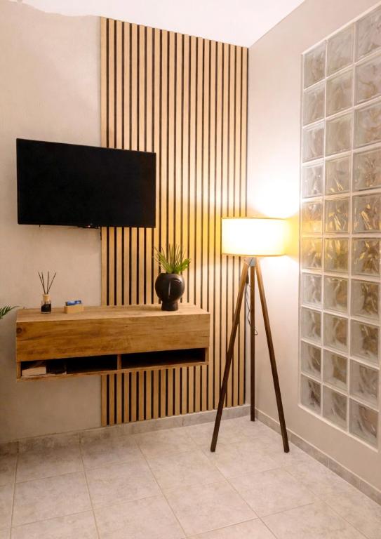 a living room with a television on a wall at Studio Ocean in Paralia Dionysiou