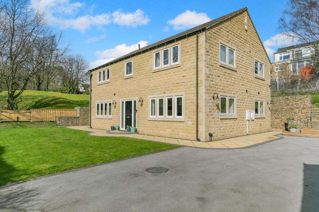a large brick house with a driveway at 4 Bed in Holmfirth oc-s31134 in Holmfirth
