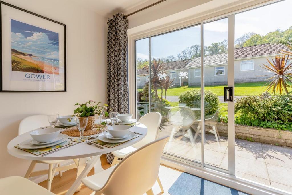 a dining room with a table and chairs and a large window at 2 Bed in Oxwich oc-l31089 in Oxwich