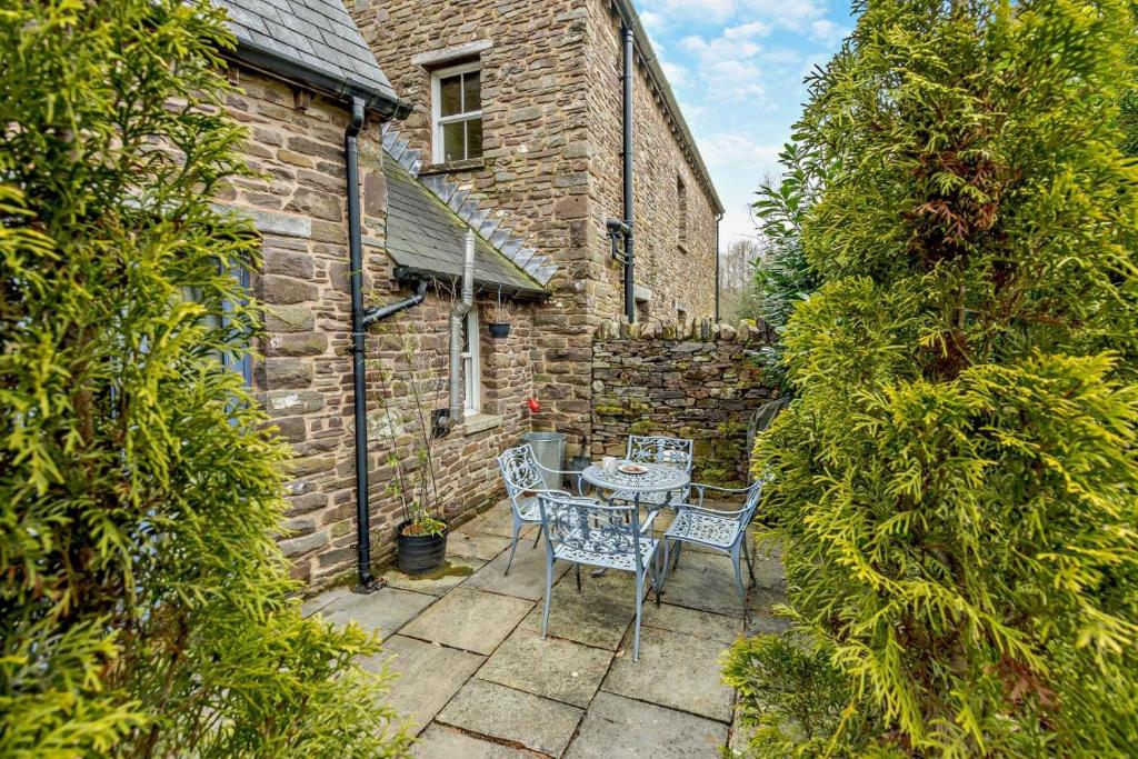 a patio with a table and chairs in front of a building at 2 Bed in Pentre Bach oc-b30875 in Pentre-bâch