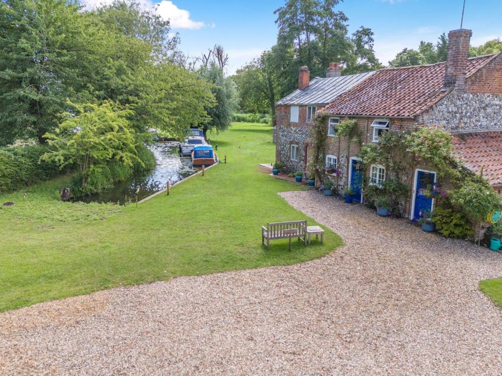 a bench in front of a house next to a river at 2 Bed in Stalham oc-u32571 in Stalham