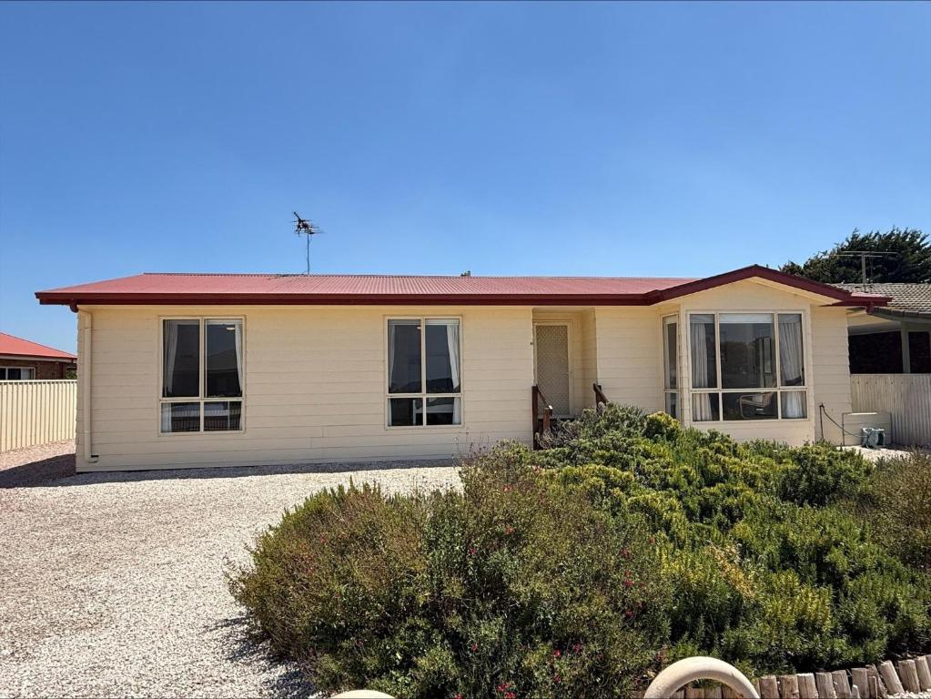 a small white house with a red roof at Sea Change Coobowie in Coobowie