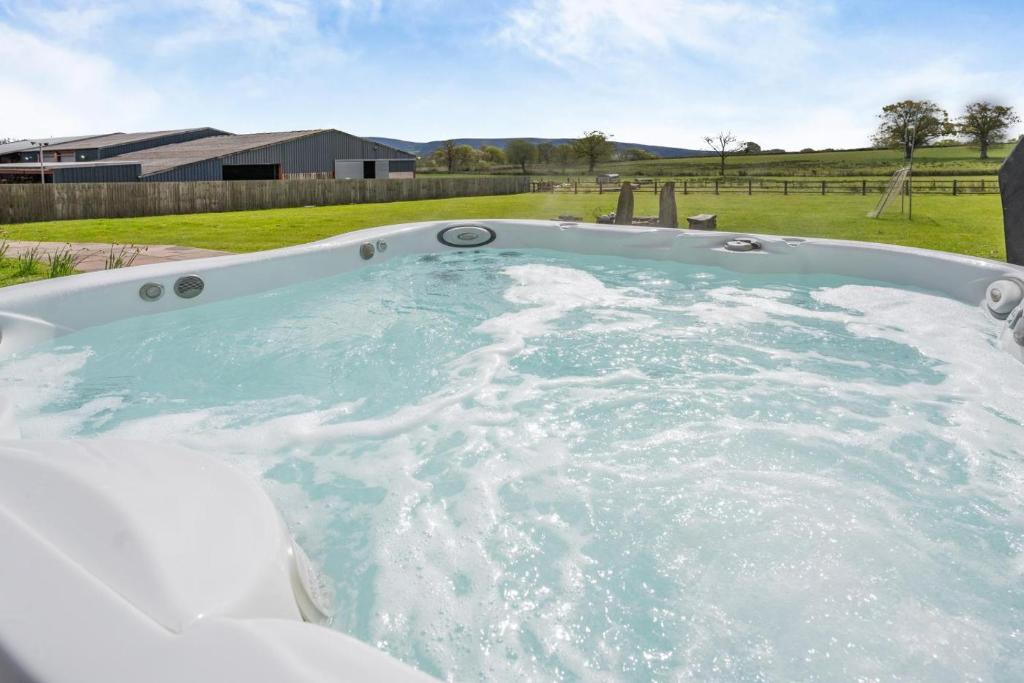 a large jacuzzi tub in a yard at 6 Bed in Llanwern oc-w31947 in Brecon