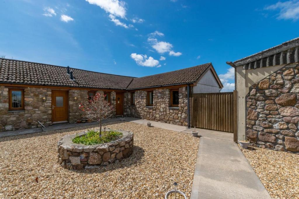 a stone house with a garden in front of it at 2 Bed in Gower oc-hh487 in Penclawdd