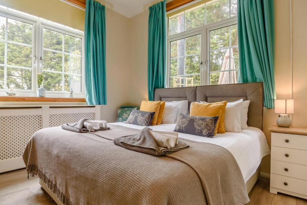 a bedroom with a bed with green curtains and windows at 1 Bed in Sizewell oc-gdnf in Sizewell