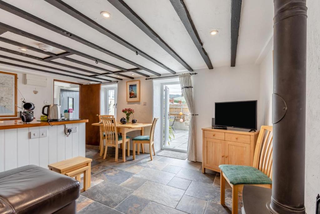 a living room with a television and a table at 2 Bed in Chideock oc-g32451 in Chideock