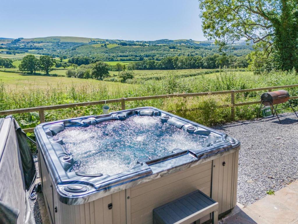 a jacuzzi tub with a view of a field at 5 Bed in Llandovery oc-bow323 in Llangadog