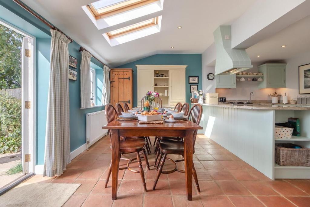eine Küche und ein Esszimmer mit einem Holztisch und Stühlen in der Unterkunft 3 Bed in Westleton Saxmundham oc-est in Westleton