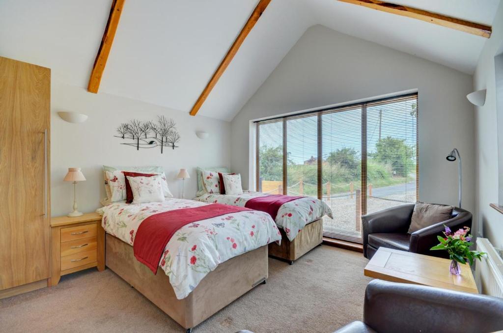 1 Bed in Acle oc-1256 في Cantley: غرفة نوم بها سرير وكرسي ونافذة