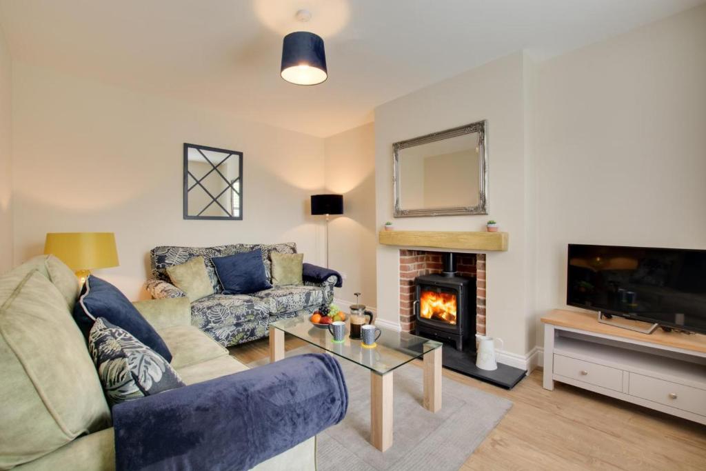 a living room with a couch and a fireplace at 2 Bed in Holt oc-2148 in Holt