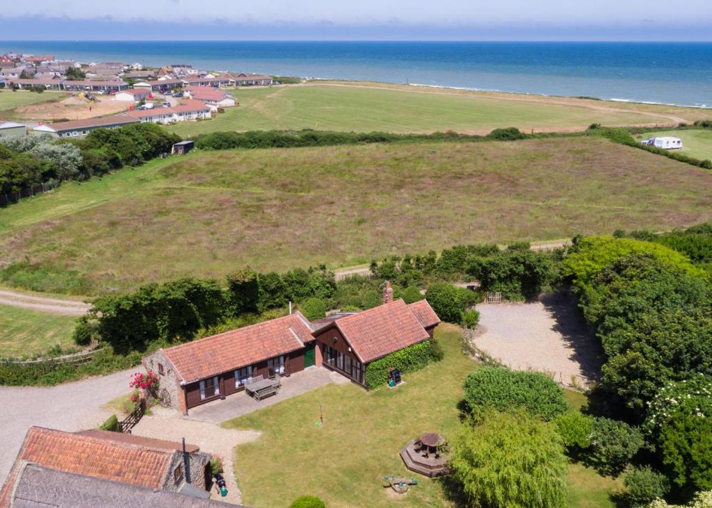 an aerial view of a house with the ocean in the background at 3 Bed in Bacton oc-711 in Bacton