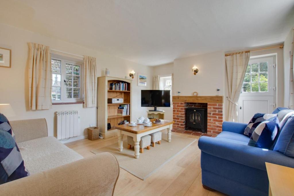 a living room with a blue couch and a fireplace at 2 Bed in Cley oc-2165 in Cley next the Sea