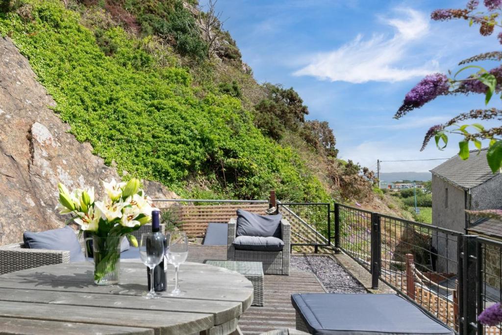 a patio with a table with flowers on it at 2 Bed in Pwllheli oc-30aber in Pwllheli