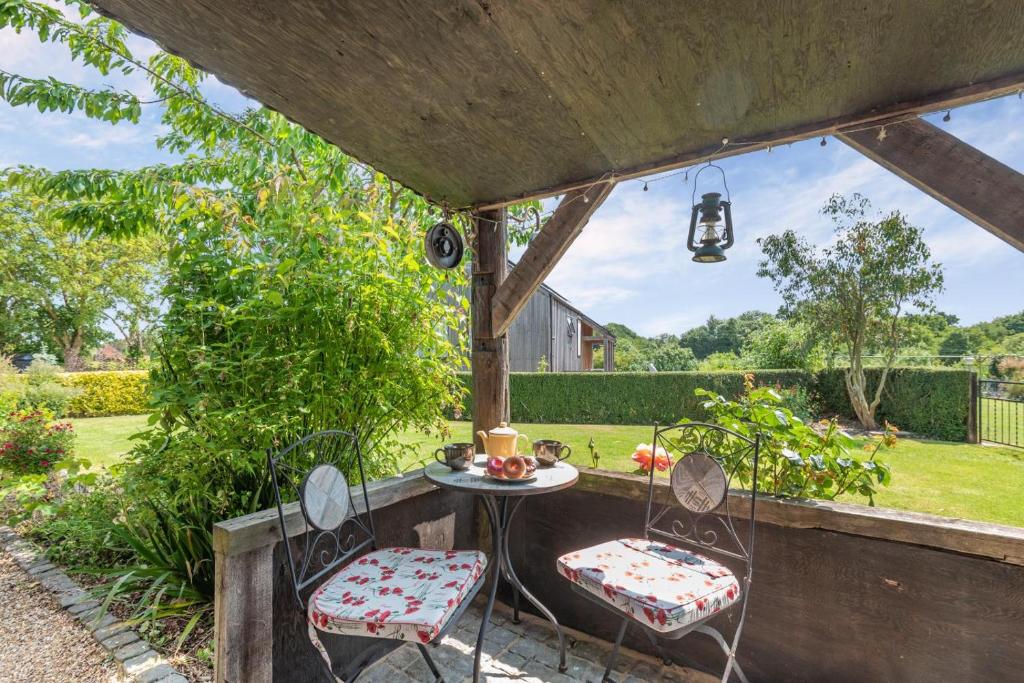 a patio with two chairs and a table in a yard at 2 Bed in Keddington oc-t32411 in Louth