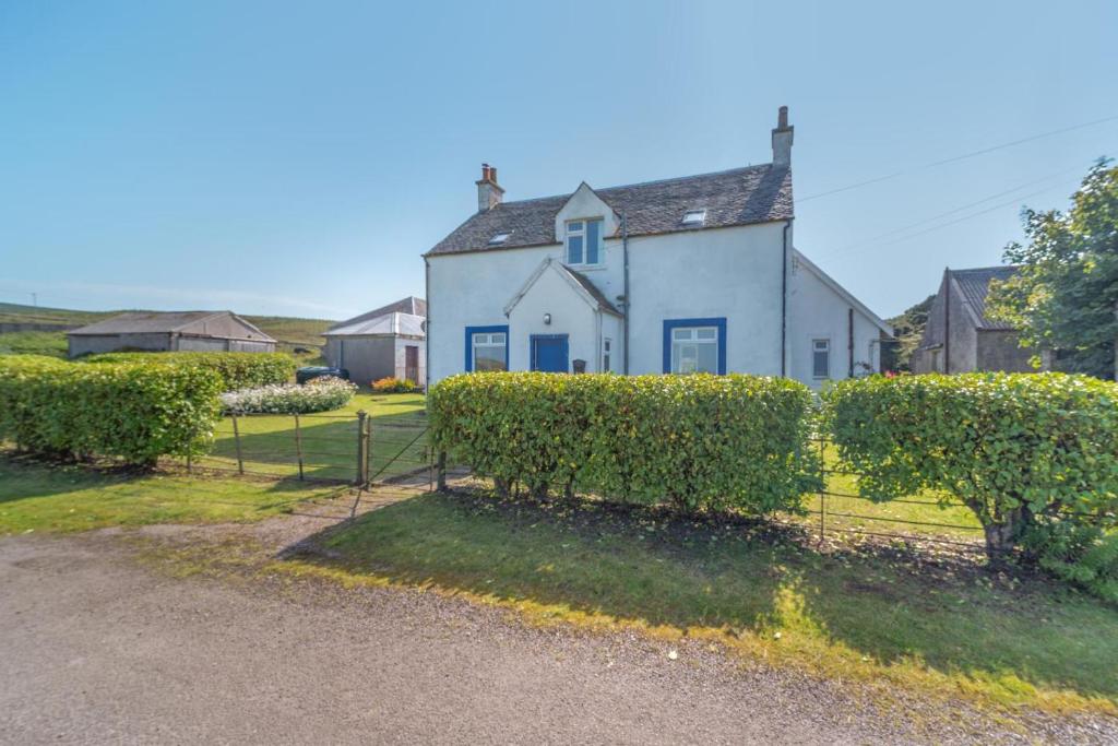 a white house with bushes in front of it at 3 Bed in Clachan oc-h32242 in Clachan