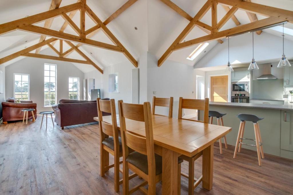 a kitchen and dining room with a wooden table and chairs at 2 Bed in Sotherton oc-dailo in Blyford