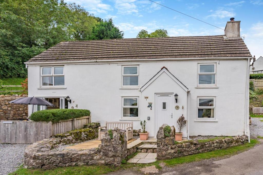 a white house with a stone wall at 2 Bed in Swansea oc-hh403 in Llanmadoc