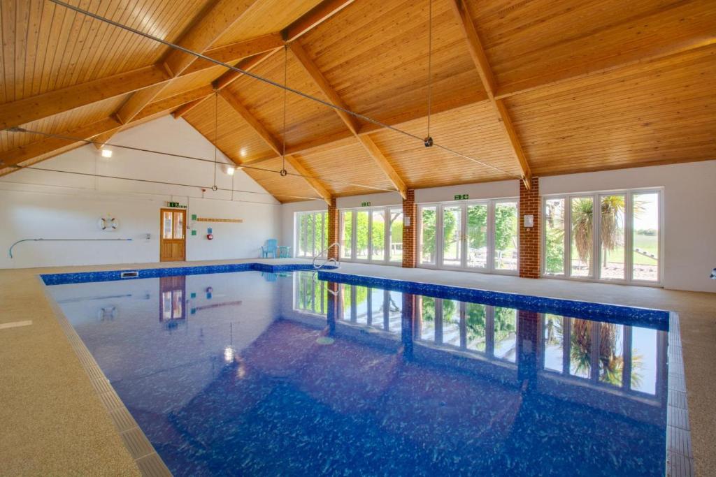 a large swimming pool in a building with wooden ceilings at 2 Bed in Roughton oc-1734 in Roughton