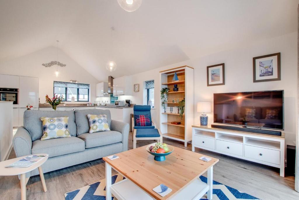 a living room with a couch and a tv at 2 Bed in Westward Ho oc-idleho in Northam