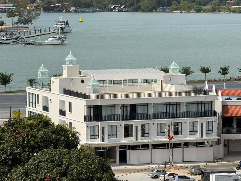 a large white building next to a body of water at ALVILLA Kampung Cina in Kuala Terengganu
