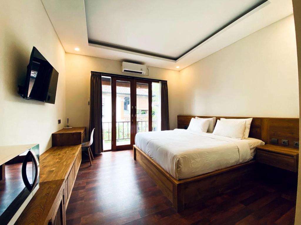 a bedroom with a bed and a television in it at Indarti Living in Sukawati