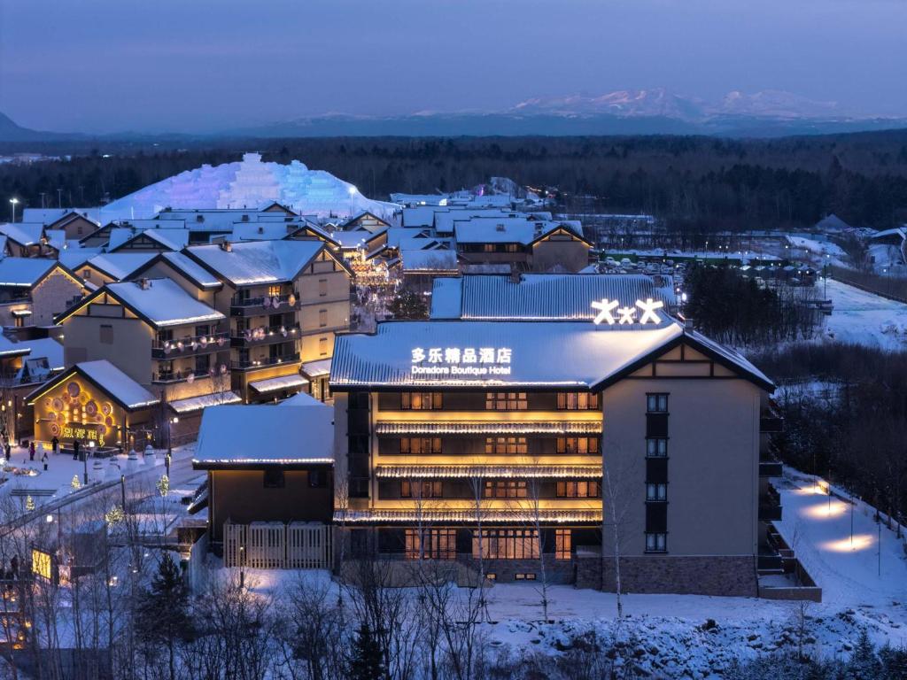 a hotel in a town with snow covered roofs at Doradora Boutique Hotel in Fusong