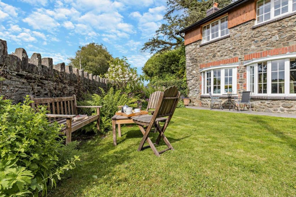 two chairs and a table in the yard of a stone house at 3 Bed in Cemmaes Road oc-h29101 in Cemmaes