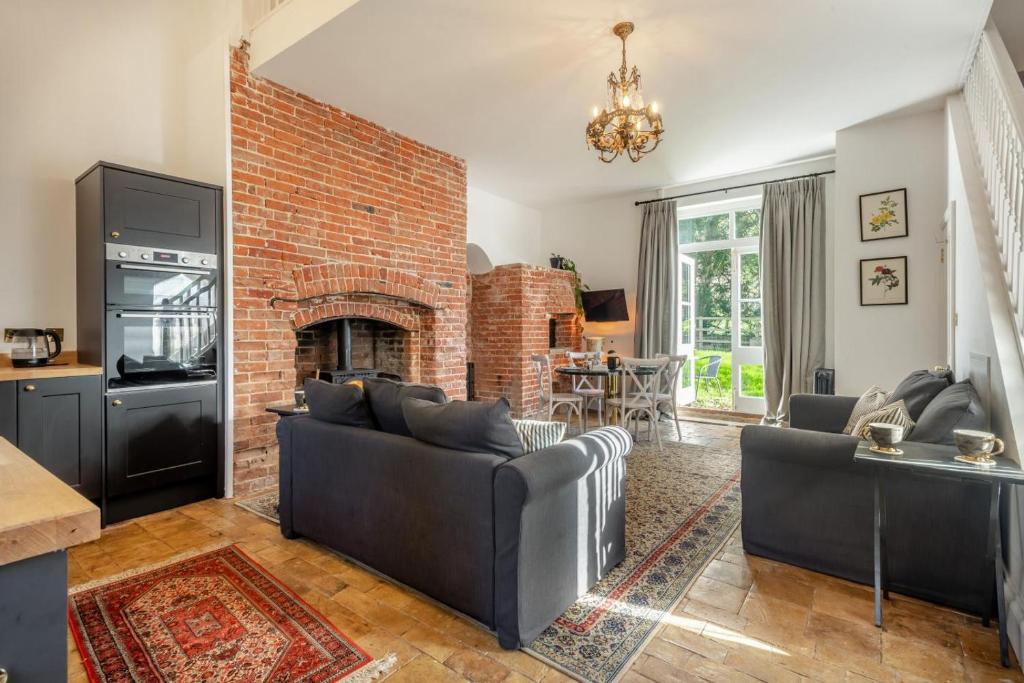a living room with couches and a brick fireplace at 3 Bed in Bessingham oc-b28837 in Thurgarton