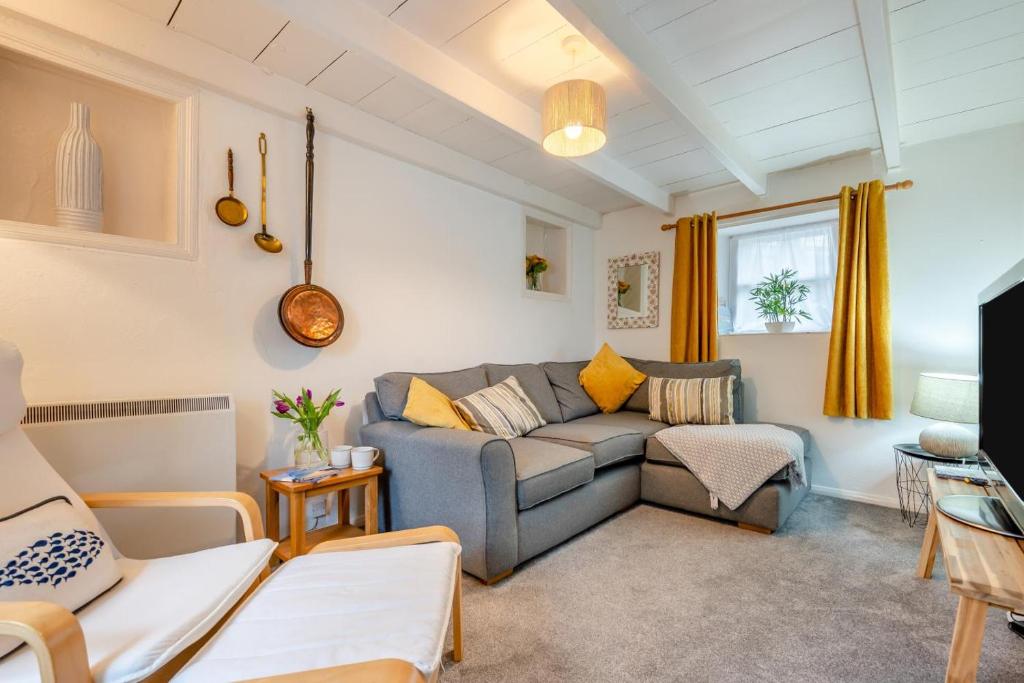 a living room with a gray couch and yellow pillows at 2 Bed in St. Teath oc-shilli in Saint Teath