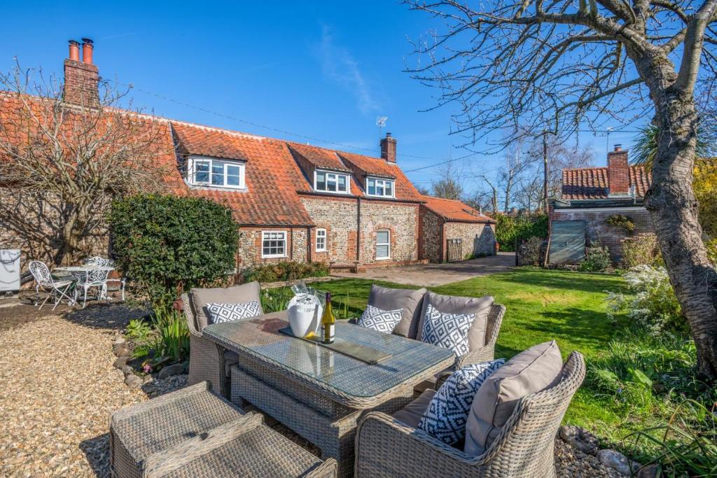 a patio with a table and chairs in front of a house at 2 Bed in Wiveton oc-g29762 in Wiveton