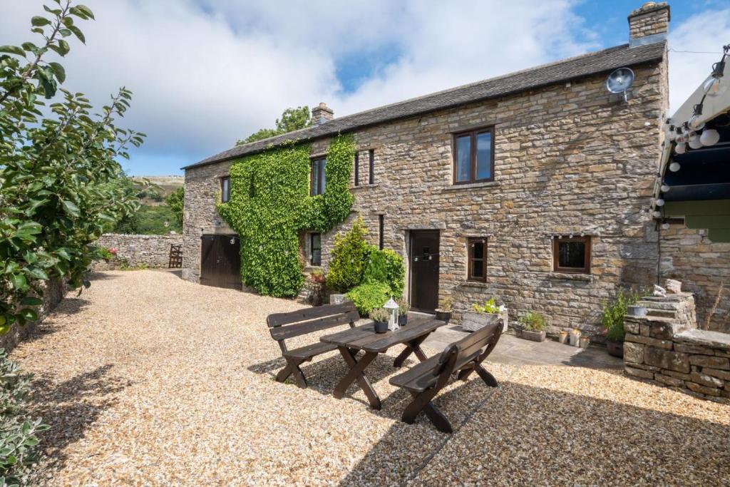 a stone house with two benches in front of it at 3 Bed in Carperby oc-ds1033 in Carperby