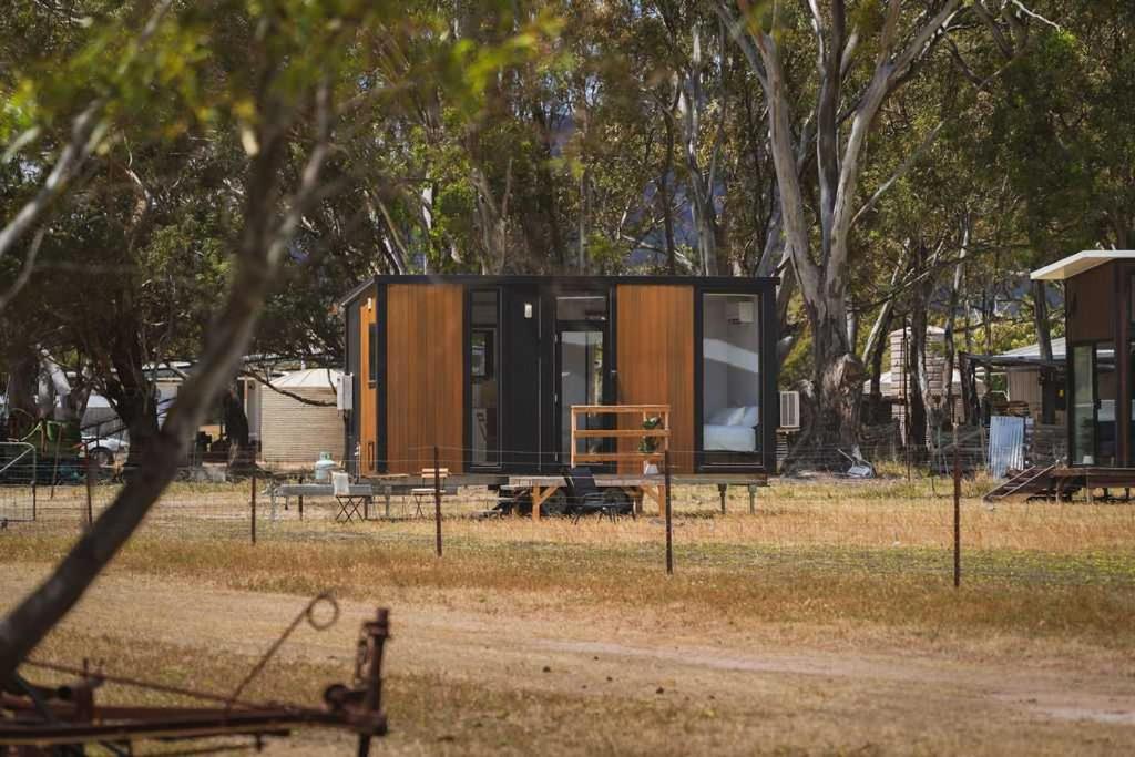 a tiny house in a field with trees at Bellellen Park 1 by Tiny Away in Stawell