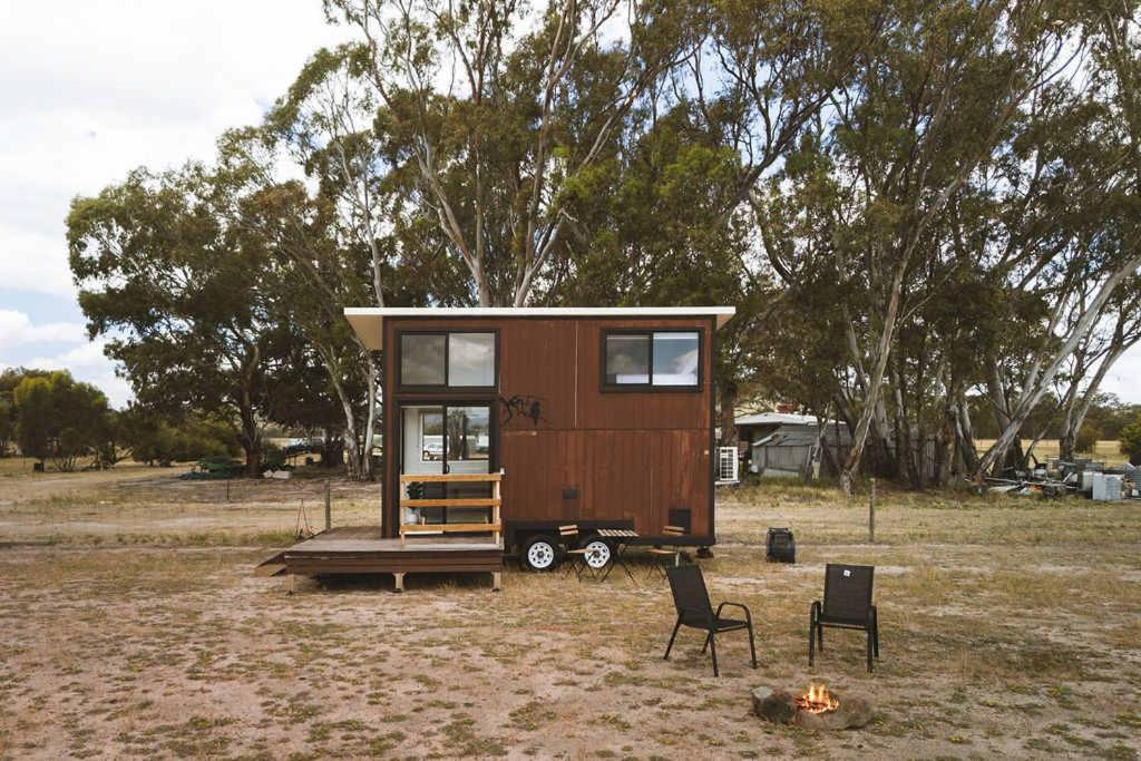 a tiny house sitting on a trailer in a field at Bellellen Park 2 by Tiny Away in Stawell